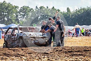 people on a Stockcar on a dirty track at a Stockcar challenge.