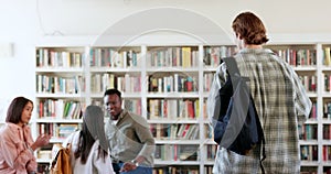 People, students walking or man in library for education, knowledge or study group for college project. Learning, fist