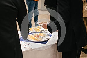 People in suits serve themselves at the buffet and eat delicious food at a business event