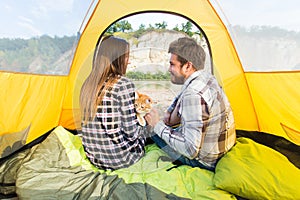 People, summer tourism and nature concept - young couple resting in camping tent, view from inside