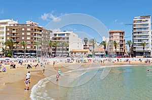 People sunbath swim at Playa del Cura beach, Torrevieja, Spain