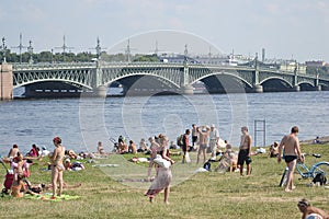 People sunbathe on the lawn.