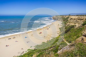 People sunbathing on a sandy beach on the Pacific Ocean coastline