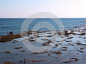 People sunbathing at sunset on the beach of La Caleta in the bay of Cadiz, Andalusia. Spain.