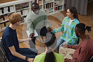 People in support group circle holding hands