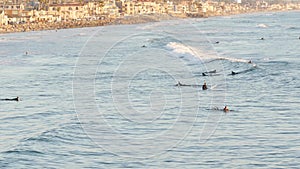 People surfing, surfers swimming in water and waiting sea wave, Oceanside, California USA