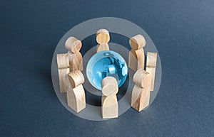 People surrounded a blue glass globe. Concept of cooperation and collaboration of people and countries around the world.