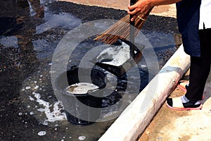 People are sweeping dirty water at ground streets, cleaner floor, housemaid, housekeeper, homemaker, maidservant, maid photo