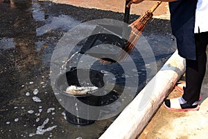 People are sweeping dirty water at ground streets, cleaner floor, housemaid, housekeeper, homemaker, maidservant, maid photo