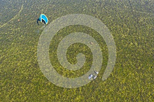 People swim in the sea on a kiteboard or kitesurfing. Summer sport learning how to kitesurf. Kite surfing on Puck bay in Jastarnia