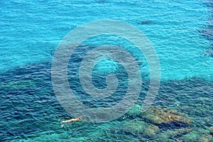 People swimm and snorkeling inside paradise clear torquoise blue water in Favignana island, Bue Marino Beach, Sicily Sout