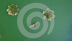 People swimming on boats by lake water. Floating flower beds on green water. Active rest on water. Aerial landscape from