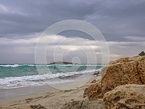 Beautiful Nissi beach with rolling sea with waves on a cloudy murky day in Ayia Napa, Cyprus