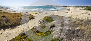 People take sun bath on the beach located near Sampieri town, Sicily.