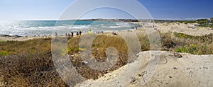 People take sun bath on the beach located near Sampieri town, Sicily.