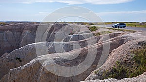 People taking dangerous photos right by the cliff in Badland national park during summer.