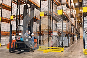 People talking by forklift truck in warehouse