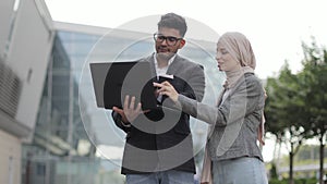 People and technologies concept. Attractive business couple of arab man and Muslim woman in smart casual style, standing