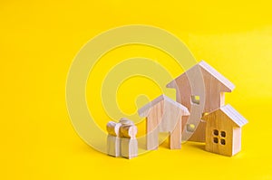People and three houses on a yellow background. Buying and selling of real estate, construction. Apartments and apartments. City,
