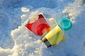 People throw coffee cups on snow. A pile of abandoned garbage on the street. Scattered food waste, cans of cola, beverage, fast