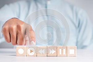 People touch the wood blocks with their index fingers. With a music player button to select a play icon