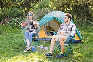 People, tourism and nature concept - Couple having fun on camping trip