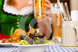 People in traditional Bavarian Tracht eating in restaurant or pub