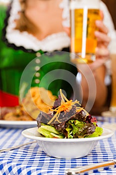 People in traditional Bavarian Tracht eating in restaurant or pub