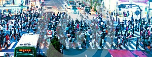 People and traffic cross the famous scramble intersection in Shibuya, Tokyo, Japan