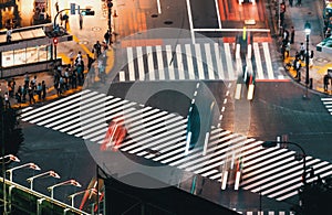 People and traffic cross the famous scramble intersection in Shibuya, Tokyo, Japan