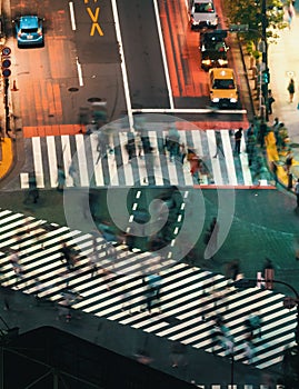 People and traffic cross the famous scramble intersection in Shibuya, Tokyo, Japan