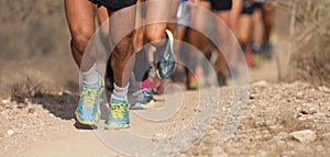 People trail running on a mountain path