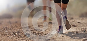 People trail running on a mountain path