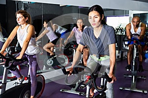 People training on cycling machines in gym