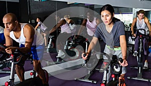 People training on cycling machines in gym