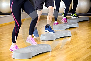 People training with step platform at fitness gym center