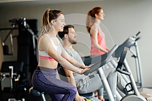 People traning in gym on various machines