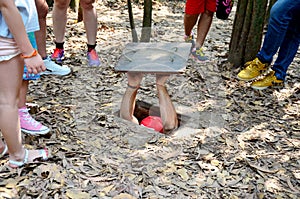 People travel and trying to play entering tunnel at Cu Chi Tunne photo