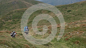 People travelers with backpacks hiking in mountains.