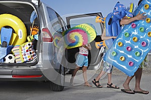 People Unloading Beach Accessories From Car photo
