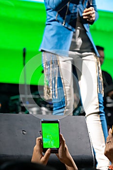 People use mobile phones to live or take pictures at concerts, with bright lights at night.