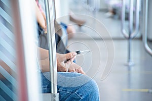 People uses mobile phone with earphones while travel by subway or train
