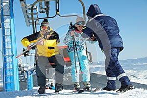 People using chairlift at mountain ski resort. Winter