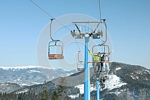 People using chairlift at mountain ski resort. Winter vacation