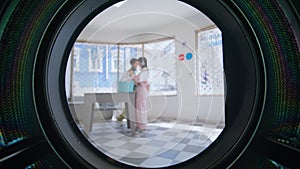 People using laundromat room in city. Closeup young hispanic man loading clothes