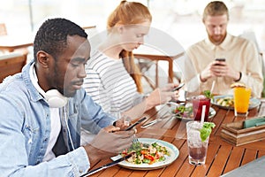 People using mobile phones in cafe