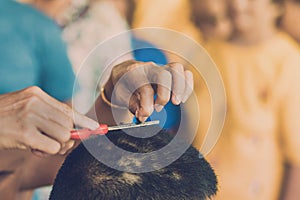 People using scissors to trim hair before ordination ceremony