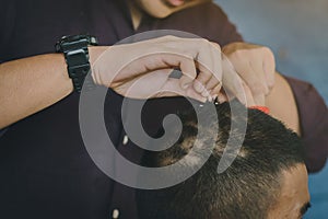 People using scissors to trim hair before ordination ceremony