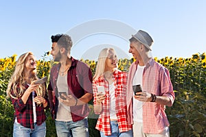 People using smart phone chatting group friends outdoor countryside sunflowers field