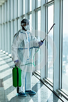 People in virus protective suits and mask disinfecting buildings of coronavirus with the sprayer